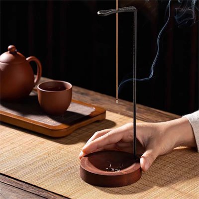 Porte encens poussé par une main